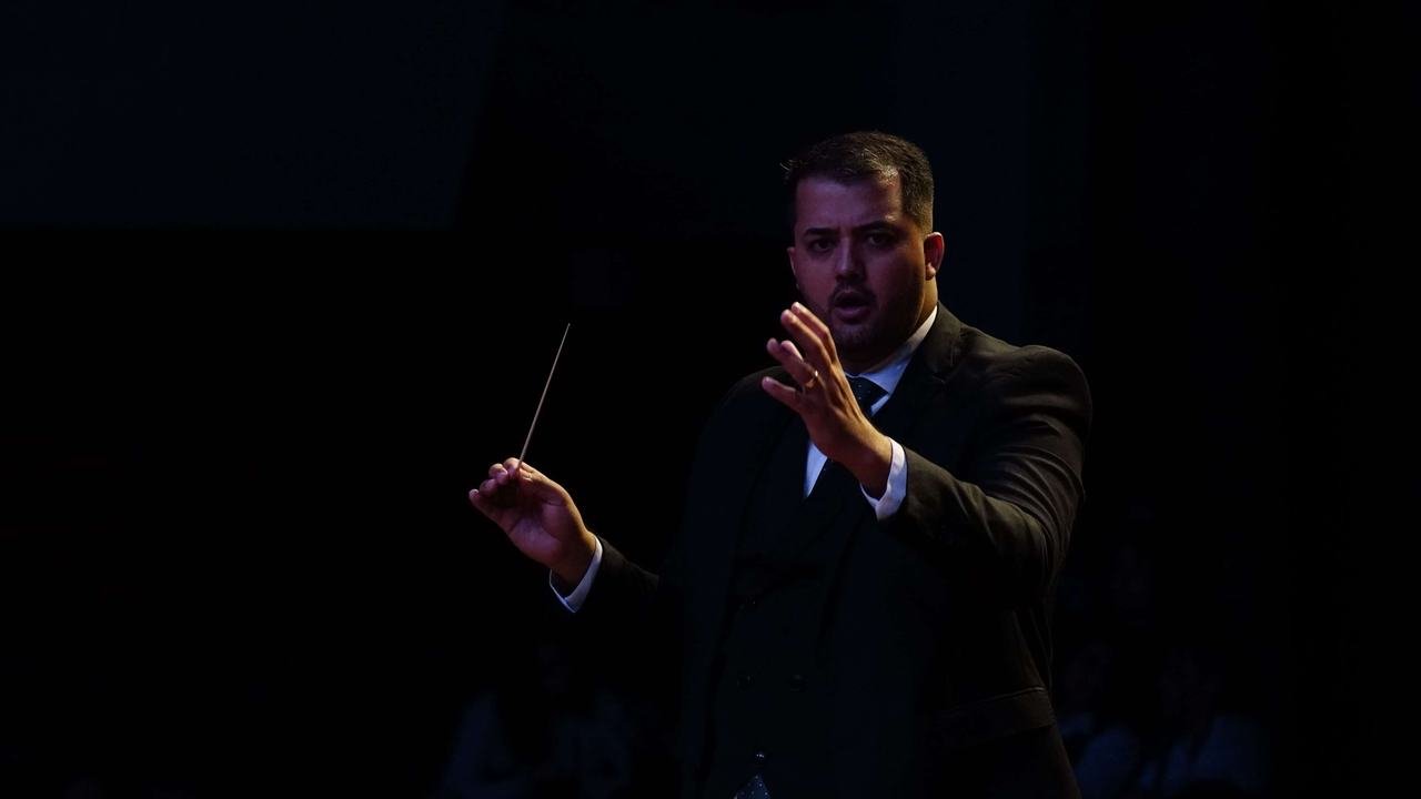 Maestro regendo a orquestra em concerto